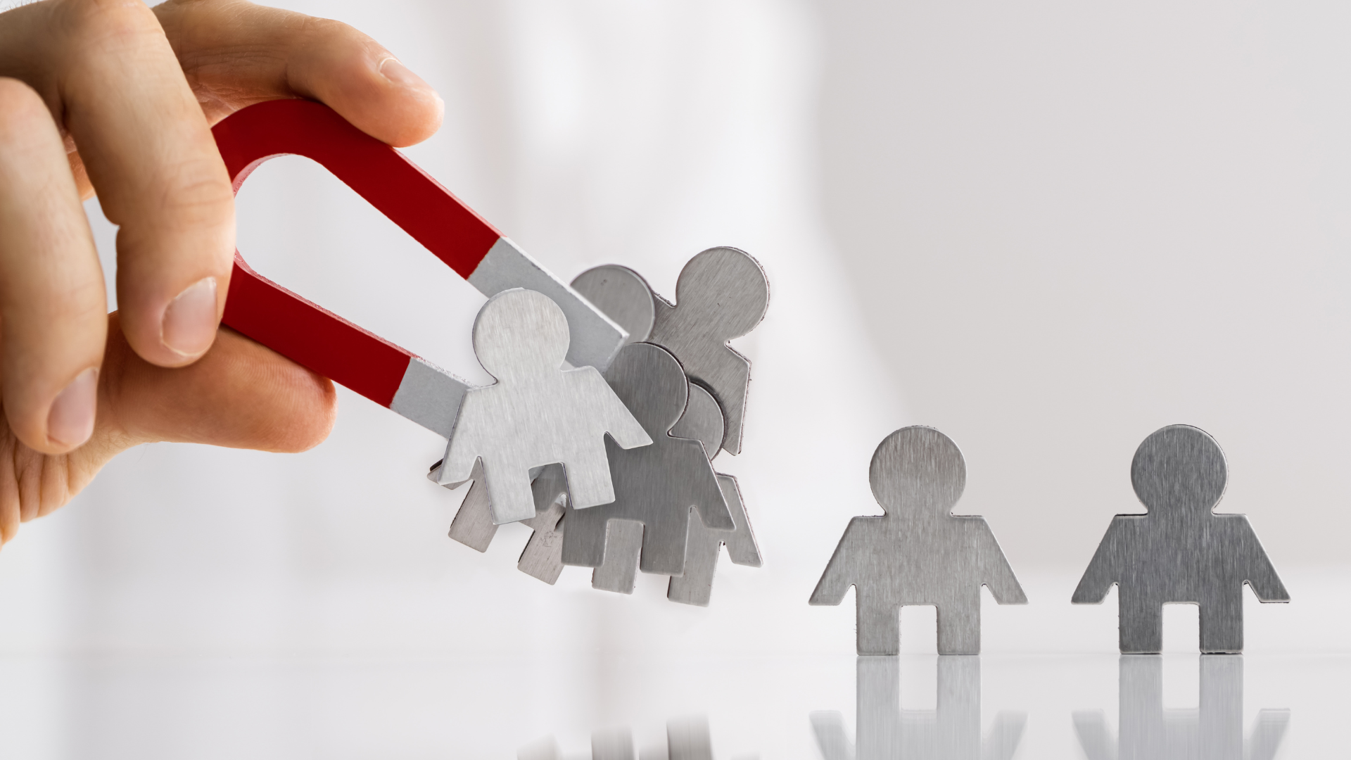 “A red magnet attracting wooden figures symbolizing ideal customers—representing how ecommerce lead magnets draw in high-intent buyers”